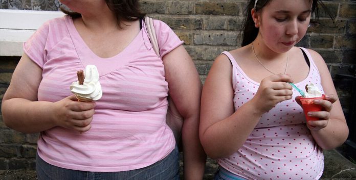 At Least 1 in 3 Americans Aged 18 to 25 Are Obese, Finds Study 2 overweight women eating icecream